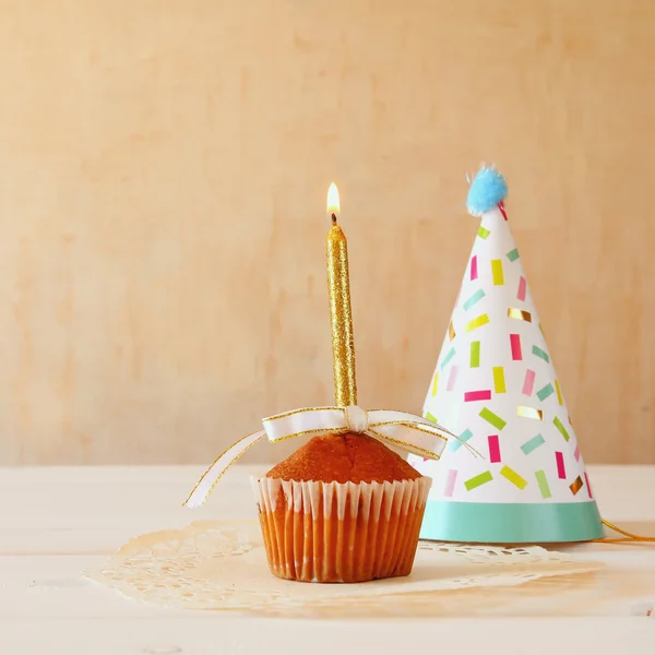 Concepto de cumpleaños con cupcake y vela, sombrero de fiesta — Foto de Stock