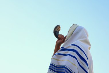 Jewish man blowing the Shofar (horn) of Rosh Hashanah (New Year) clipart