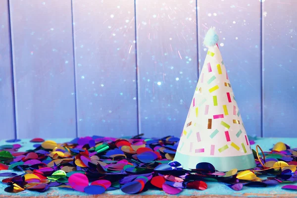 Sombrero de fiesta y confeti colorido en mesa de madera —  Fotos de Stock