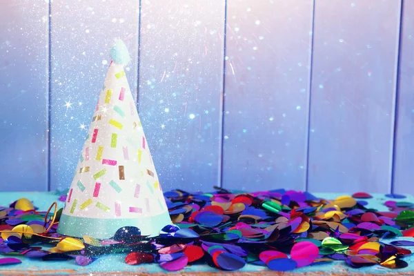 Party kalap és színes konfetti a fából készült asztal — Stock Fotó