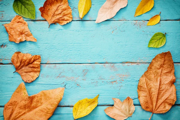 Fundo de outono com folhas secas na mesa de madeira — Fotografia de Stock