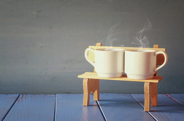 Un par de tazas de café en el banco viejo. filtrado vintage . — Foto de Stock