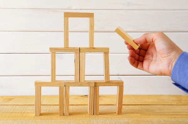 Macho mano construir una torre de ladrillos de dominó — Foto de Stock