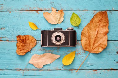 Kuru yaprakları ve eski fotoğraf makinesi ile sonbahar arka plan