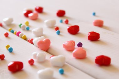 Kırmızı, pembe ve beyaz kalp şekli şekerler ahşap tablo