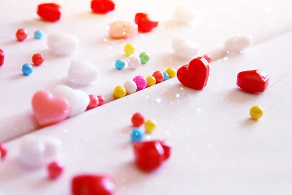 Corazones rojos, rosados y blancos dan forma a caramelos en mesa de madera — Foto de Stock