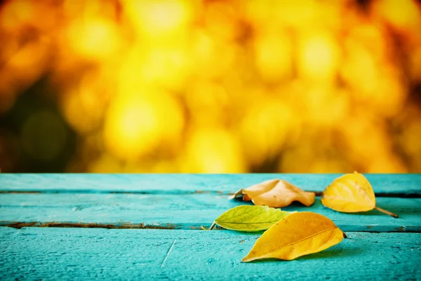 Podzimní pozadí s suché listí na dřevěný stůl — Stock fotografie