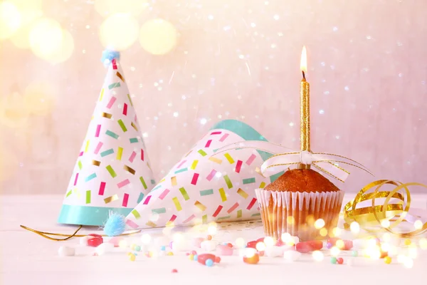 Birthday concept with cupcake and candle, party hat — Stock Photo, Image