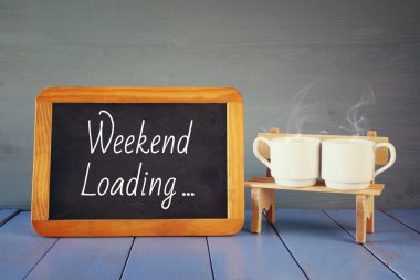 kahve bardakları yanındaki metinle yazı tahtası: hafta sonu yükleme
