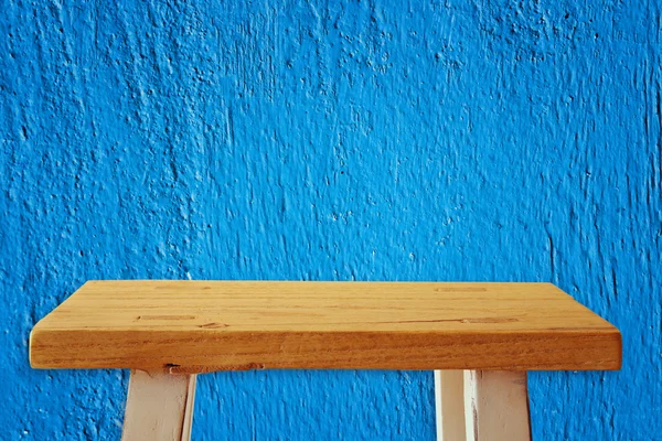 Mesa pequena vazia na frente do fundo da parede azul — Fotografia de Stock