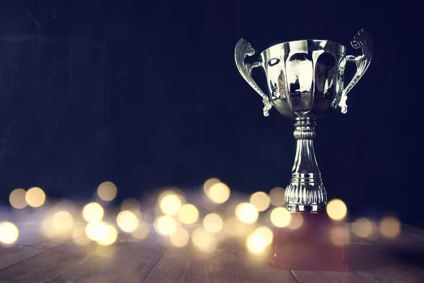 Lage belangrijke beeld van trofee over houten tafel — Stockfoto