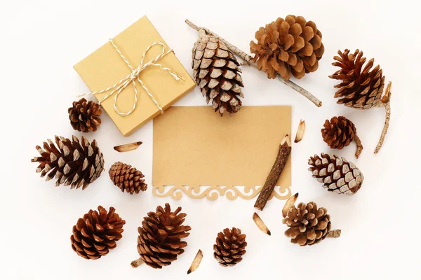 Vista superior de cones de pinho, caixa de presente e cartão em branco — Fotografia de Stock