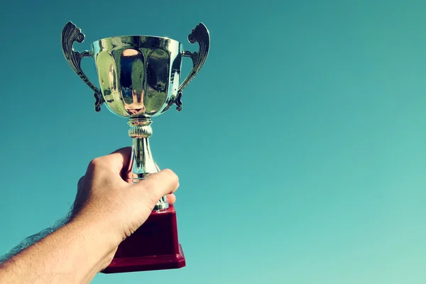 Hombre sosteniendo una copa de trofeo como ganador — Foto de Stock