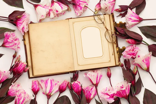 Prachtige roze bloemen en oude leeg fotoalbum — Stockfoto