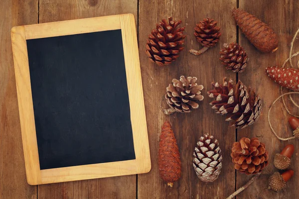 Top view of pine cones and blank blackboard — Stock Photo, Image