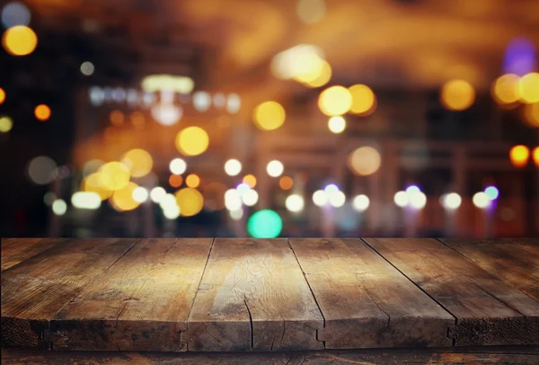 Wooden table in front of abstract blurred restaurant lights - Stock Image -  Everypixel