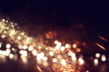 Soyut altın ve siyah parıltılı ışıkların arkaplanı. Odaklanamadı