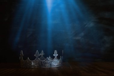 Tahta masanın üzerindeki güzel kraliçe ve kral tacının gösterişsiz görüntüsü. Eski model filtrelenmiş. fantezi ortaçağ dönemi