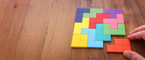 Mão Homem Segurando Quebra Cabeça Tangram Quadrado Sobre Mesa Madeira — Fotografia de Stock