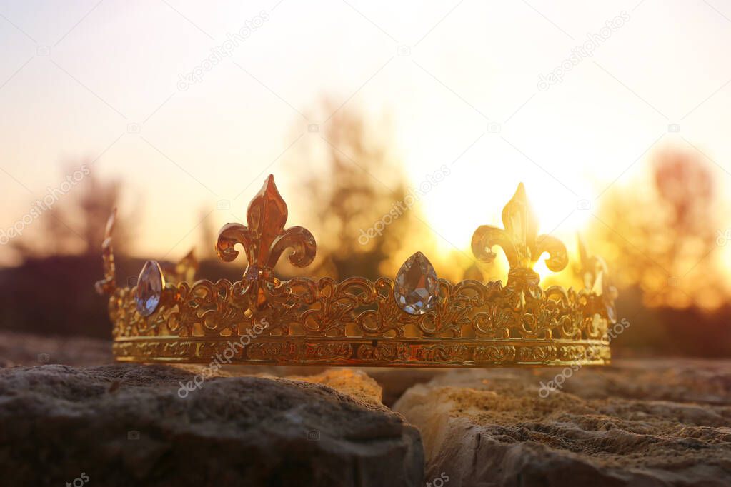 mysterious and magical photo of gold king crown in the England woods over stone. Medieval period concept.