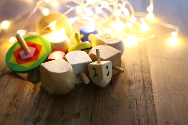 Banner of jewish holiday Hanukkah with wooden dreidels (spinning top) over wooden background