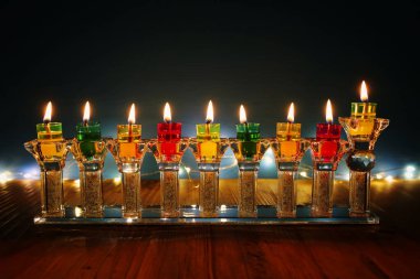 image of jewish holiday Hanukkah background with crystal menorah (traditional candelabra) and oil candles clipart