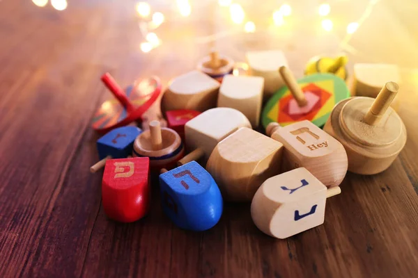 Banner of jewish holiday Hanukkah with wooden dreidels (spinning top) over wooden background