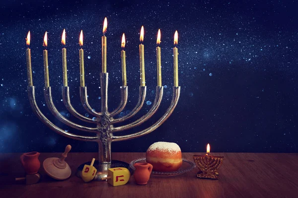 ユダヤ人の休日の画像MenorahとHanukka 伝統的なカンデラブラ ドーナツと木製のドリデル 上回転 — ストック写真