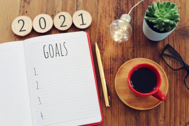Üst görünüm iş konsepti 2021 gol listesi, defter, ahşap masa üzerinde kahve