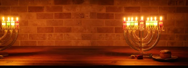 Image of jewish holiday Hanukkah with menorah (traditional Candelabra), donut and wooden dreidel (spinning top)