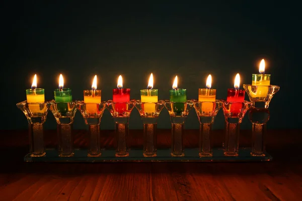image of jewish holiday Hanukkah background with crystal menorah (traditional candelabra) and oil candles