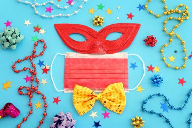 Maskeli balo maskesi arkaplanının en üst görünümü. Düz yatıyordu. Purim kutlaması (Yahudi karnavalı bayramı). Coronavirus önleme konsepti, tıbbi maske