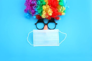karnaval, parti ve Purim kutlaması (Yahudi karnavalı bayramı) mavi arka planda. Coronavirus önleme konsepti, tıbbi maske ve dezenfektan jeli