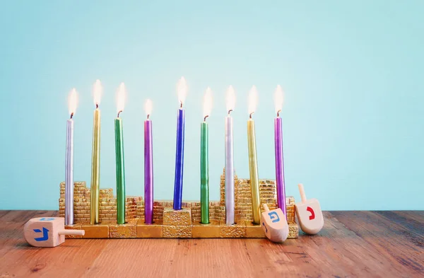 Image of jewish holiday Hanukkah with menorah (traditional Candelabra), donut and wooden dreidel (spinning top)