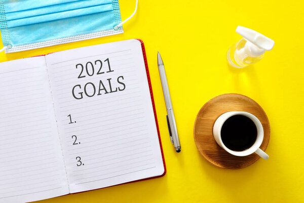 Бизнес-концепция списка целей на 2021 год с ноутбуком, чашкой кофе над деревянным столом