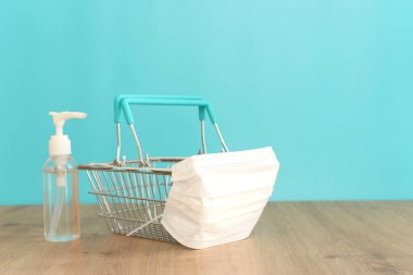 Sepet ya da koruyucu maskeli alışveriş arabası. COVID 19 salgını sırasında güvenli alışverişi sürdürmek