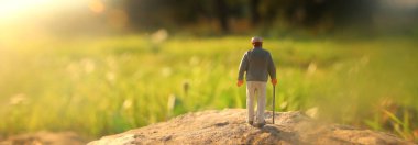 Gün batımında tarlada yalnız yürüyen gizemli bir adamın gerçeküstü görüntüsü.