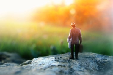 Gün batımında yalnız yürüyen gizemli bir adamın gerçeküstü görüntüsü.