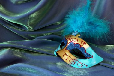 Mavi ipek arka planda zarif ve narin Venedik maskesinin fotoğrafı