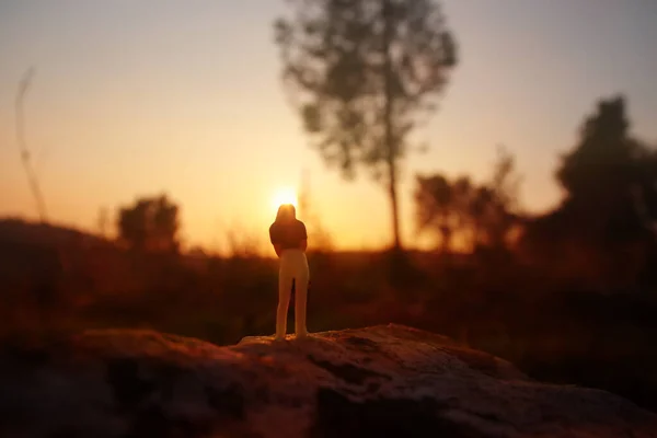 日没時に一人で歩く謎の女性のシュールなイメージ — ストック写真