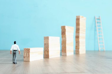 İş konsepti meydan okuma. Bir adam yüksek bir duvarın kenarında durur ve bir merdiven yerleştirerek boşluğu geçer. Sorun çözme ve karar verme.