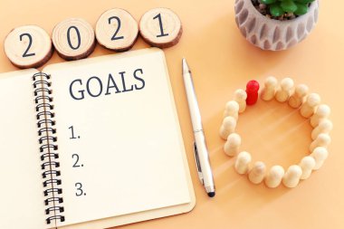 Üst görünüm iş konsepti 2021 hedef listesi ve pastel arkaplan üzerinde not defteri