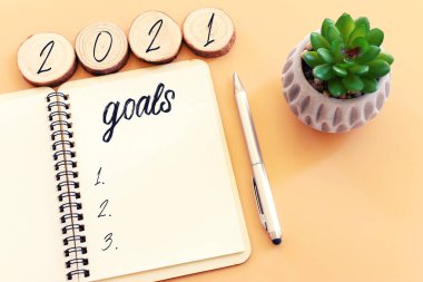 Üst görünüm iş konsepti 2021 hedef listesi ve pastel arkaplan üzerinde not defteri