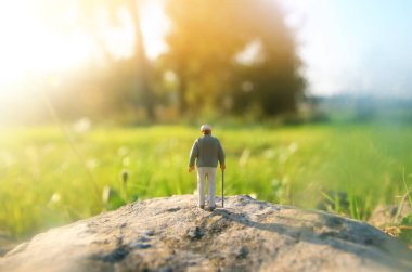 Gün batımında tarlada yalnız yürüyen gizemli bir adamın gerçeküstü görüntüsü.