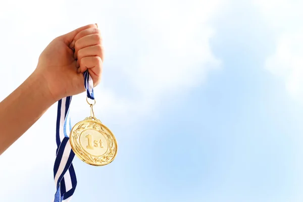 Mão Mulher Levantada Segurando Medalha Ouro Contra Céu Conceito Prêmio — Fotografia de Stock