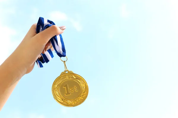 Frau Hebt Die Hand Und Hält Goldmedaille Gegen Den Himmel — Stockfoto