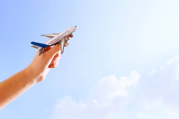 Bir Kadının Elinde Mavi Gökyüzü Bulutlu Oyuncak Bir Uçağı Tutarken — Stok fotoğraf