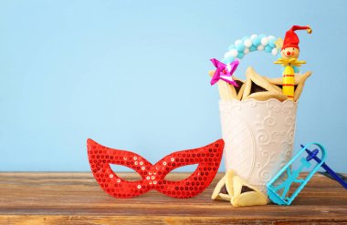 Ahşap masa ve mavi arka plan üzerinde Purim bayramı konsepti (Yahudi karnavalı bayramı)