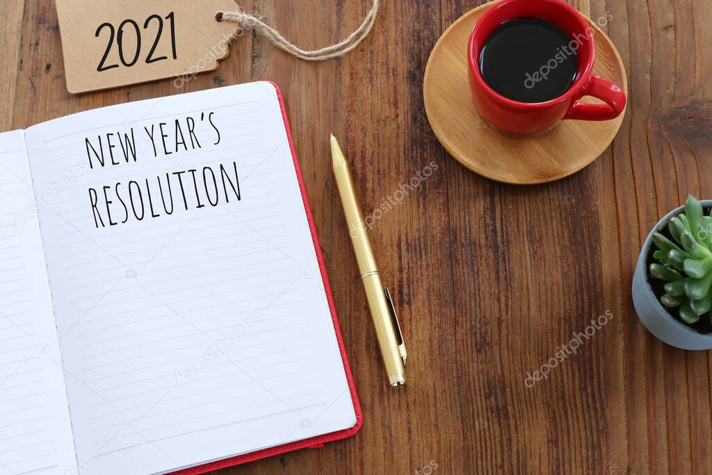 Business concept of top view 2021 resolution with notebook, cup of coffee over wooden desk