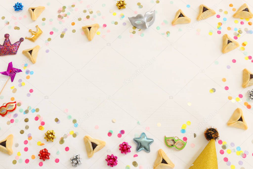 Purim celebration concept (jewish carnival holiday) over wooden white background. Top view, flat lay